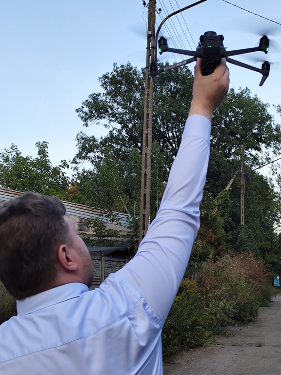 Członek zespołu badawczego wraz z dronem