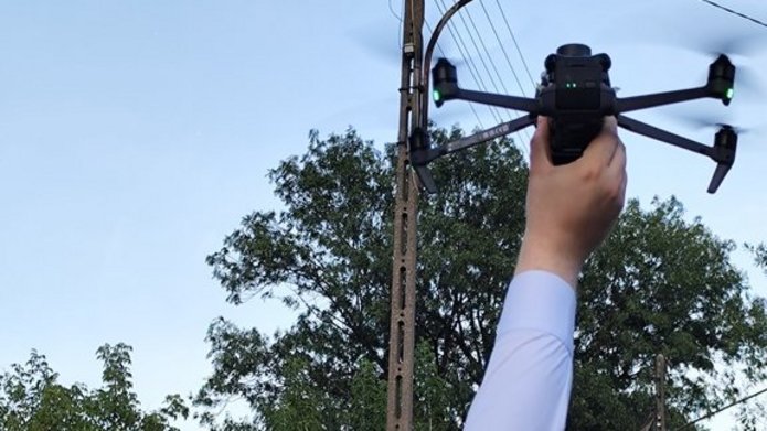 Członek zespołu badawczego wraz z dronem