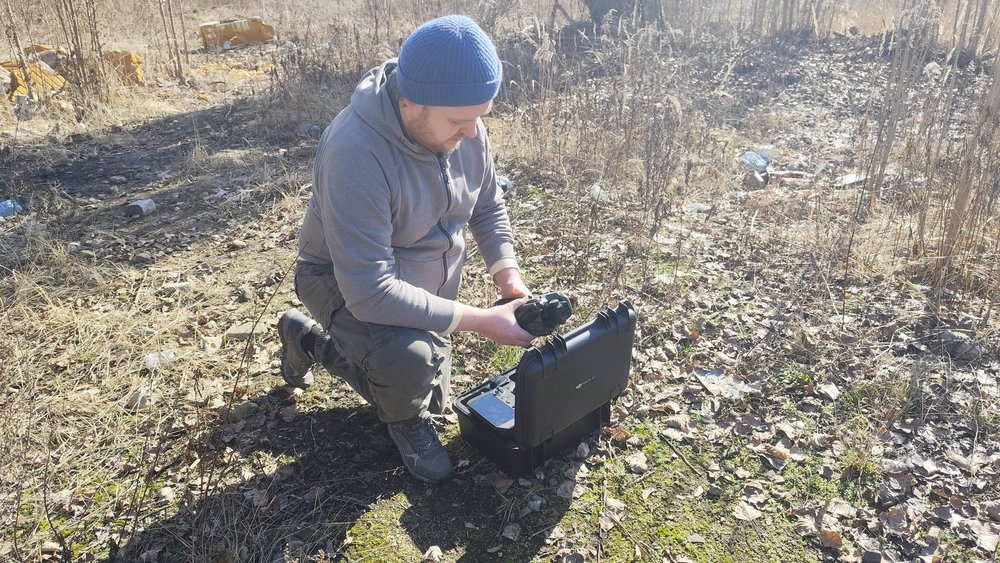 Członek zespołu (Maciej Adamiak) uruchamiający drona przed nalotem